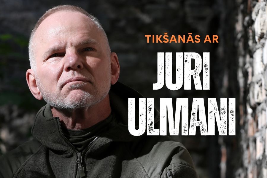 Reklāmas attēls pasākumam Saldus novada bibliotēkā. Attēlā redzama persona tumšā virsjakā uz akmeņaina fona. Labajā pusē izvietots uzraksts oranžā un baltā krāsā: “Tikšanās ar Juri Ulmani”. Tumšs, kontrastains vizuālais noformējums uzsver piedzīvojumu un ekspedīciju tematiku. Pasākums notiks Saldus novada bibliotēkā 2026. gada 29. oktobrī plkst. 17.00.