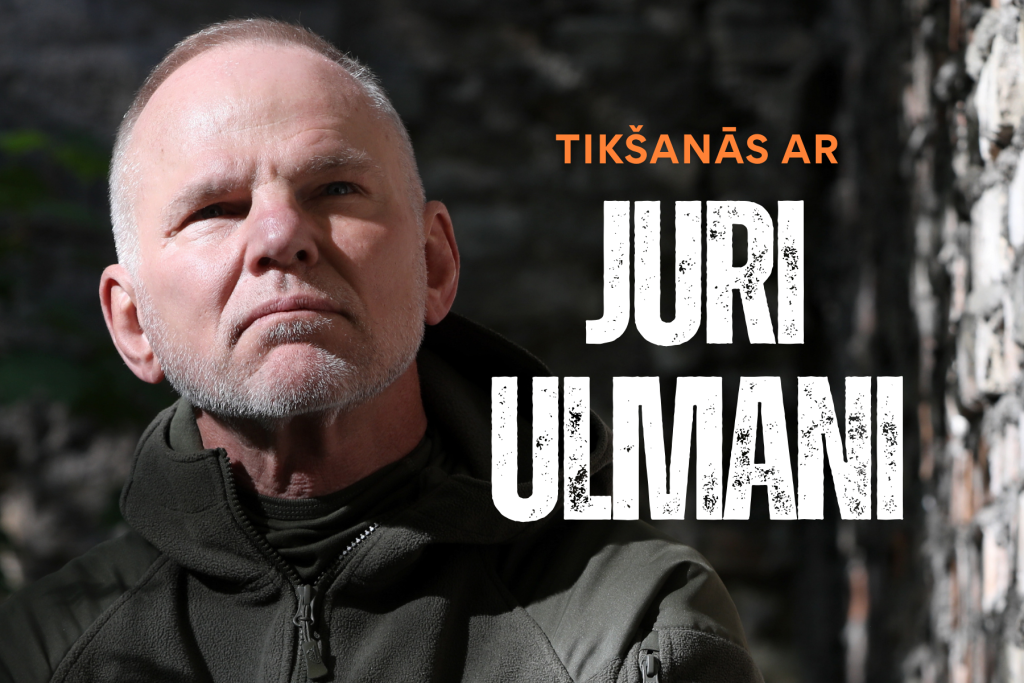 Reklāmas attēls pasākumam Saldus novada bibliotēkā. Attēlā redzama persona tumšā virsjakā uz akmeņaina fona. Labajā pusē izvietots uzraksts oranžā un baltā krāsā: “Tikšanās ar Juri Ulmani”. Tumšs, kontrastains vizuālais noformējums uzsver piedzīvojumu un ekspedīciju tematiku. Pasākums notiks Saldus novada bibliotēkā 2026. gada 29. oktobrī plkst. 17.00.